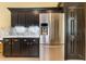 Kitchen featuring stainless steel appliances, black cabinets, and stone countertops at 24515 Bocage Way, Leesburg, FL 34748