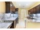 Kitchen featuring stainless steel appliances, dark cabinets, and granite countertops at 24515 Bocage Way, Leesburg, FL 34748