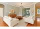 Bright living room with hardwood floors and white couches at 24515 Bocage Way, Leesburg, FL 34748