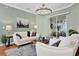 Inviting living room featuring a chandelier, stylish furniture, and sliding glass doors at 24515 Bocage Way, Leesburg, FL 34748