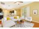 Open living room with hardwood floors and a neutral-colored sofa at 24515 Bocage Way, Leesburg, FL 34748