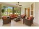 Inviting sunroom with wicker furniture and view of landscaped yard at 24515 Bocage Way, Leesburg, FL 34748