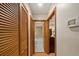Hallway featuring wood closet doors and an entryway leading to the bathroom at 2696 Orange Peel Ct, Orlando, FL 32806