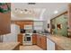 Well-lit kitchen featuring white appliances, wood cabinets and granite countertops at 2696 Orange Peel Ct, Orlando, FL 32806