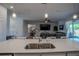 Modern kitchen features stainless steel sink, quartz countertops, and pendant lighting overlooking the living area at 2720 Bancroft Blvd, Orlando, FL 32833