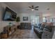 Comfortable living room with gray reclining sofas, ceiling fan, wall-mounted TV, and sliding glass doors to the lanai at 2720 Bancroft Blvd, Orlando, FL 32833