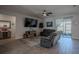 Cozy living room with comfortable gray sofas, wall-mounted TV, and sliding glass doors providing natural light at 2720 Bancroft Blvd, Orlando, FL 32833