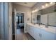 Bright primary bathroom boasting dual sinks, white cabinets, quartz countertops, and wood look flooring at 2720 Bancroft Blvd, Orlando, FL 32833