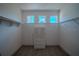 A bright, walk-in closet with a white wicker cabinet, wood look flooring, and natural light from small windows at 2720 Bancroft Blvd, Orlando, FL 32833