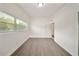 A bright bedroom features a large window, light wood floors, and a door leading to another room at 305 Hope Cir, Orlando, FL 32811