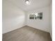 Bright, minimalist bedroom features light wood floors, white walls, a window, and ample natural light at 305 Hope Cir, Orlando, FL 32811