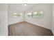 This bedroom features wood floors, white walls, and two windows for lots of natural light at 305 Hope Cir, Orlando, FL 32811