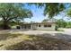 View of home showcasing the long driveway, back patio, and green surroundings at 305 Hope Cir, Orlando, FL 32811