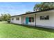 Home exterior featuring a well-manicured lawn and a bright blue front door at 305 Hope Cir, Orlando, FL 32811