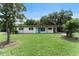 Charming single-story home featuring a well-maintained lawn and a vibrant blue front door at 305 Hope Cir, Orlando, FL 32811