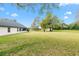 View of large backyard and exterior of home, with a spacious lawn at 30912 Fairvista Dr, Tavares, FL 32778