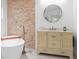 Gorgeous bathroom featuring a soaking tub, a stone accent wall, and a lovely vanity at 30912 Fairvista Dr, Tavares, FL 32778