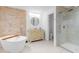 Beautiful bathroom featuring a soaking tub, stone accent wall, glass enclosed shower and a vanity at 30912 Fairvista Dr, Tavares, FL 32778