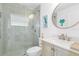 Bathroom featuring a glass shower, updated vanity, decorative mirror, and calming decor at 30912 Fairvista Dr, Tavares, FL 32778