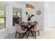 Charming dining area featuring a wooden table, four chairs, and ample natural light through large windows at 30912 Fairvista Dr, Tavares, FL 32778