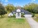 Beautiful home featuring manicured lawn, tropical plants and a lovely entrance at 30912 Fairvista Dr, Tavares, FL 32778