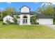 Charming two-story home with a well-manicured lawn and tropical landscaping at 30912 Fairvista Dr, Tavares, FL 32778