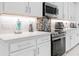 Beautiful, well-appointed kitchen featuring white cabinets, stainless steel appliances, and a sleek design at 30912 Fairvista Dr, Tavares, FL 32778