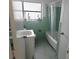 Clean bathroom with a white vanity, bathtub with shower, and green tile accents at 3243 Little Sound Dr, Orlando, FL 32827