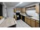 Functional kitchen with wood cabinets, black appliances, and a cozy dining area at 3243 Little Sound Dr, Orlando, FL 32827