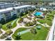 Aerial view of the community with pool, fire pit area, shuffleboard courts, and lush tropical landscaping by the water at 325 N Causeway # 2080, New Smyrna Beach, FL 32169
