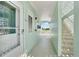 Hallway with an exit sign, stairs, white walls, and an apartment door at 325 N Causeway # 2080, New Smyrna Beach, FL 32169