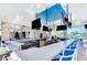 Outdoor bar featuring multiple televisions, modern countertops and comfortable blue chairs for guests at 3320 Lilac Way, Davenport, FL 33897
