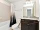 Bathroom featuring a tub with shower and vanity with granite counters and dark wood cabinets at 3320 Lilac Way, Davenport, FL 33897