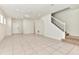 Bright open-concept living area with tile flooring and a staircase to the second level at 3320 Lilac Way, Davenport, FL 33897