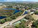 Expansive aerial view of a neighborhood featuring mature trees, a community lake, and a nearby tennis court at 3655 Seminole Dr, Orlando, FL 32812