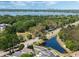 Scenic aerial shot highlighting the community tennis courts and beautiful pond with mature trees at 3655 Seminole Dr, Orlando, FL 32812