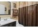 This bathroom features a modern sink and vanity, along with a shower featuring a neutral-toned shower curtain at 3655 Seminole Dr, Orlando, FL 32812