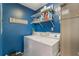 Functional laundry room with washer, dryer, shelving, and blue accent wall at 3901 Villas Green Cir # 1, Longwood, FL 32779