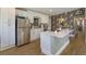 Modern kitchen with white cabinets, stainless steel refrigerator, kitchen island, and stylish floral wallpaper at 427 Zimmerman Dr, Orlando, FL 32839