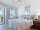 Comfortable bedroom with nautical themed decor, a large window and access to a balcony at 434 Bouchelle Dr # 202, New Smyrna Beach, FL 32169