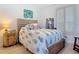 Cozy bedroom featuring a decorative headboard, pineapple patterned bedspread, and ample natural light from a shuttered window at 434 Bouchelle Dr # 202, New Smyrna Beach, FL 32169