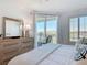 Bright bedroom features a sliding glass door to the balcony and a dresser with a mirror and decorative lamp at 434 Bouchelle Dr # 202, New Smyrna Beach, FL 32169