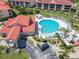 Aerial view showcases a kidney-shaped community pool surrounded by lush landscaping and lounge chairs for residents to enjoy at 434 Bouchelle Dr # 202, New Smyrna Beach, FL 32169
