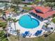 Overhead shot reveals a large community pool with ample seating, umbrellas and tropical landscaping for relaxation and enjoyment at 434 Bouchelle Dr # 202, New Smyrna Beach, FL 32169