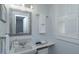 Cozy bathroom with a decorative framed mirror, ample towel storage and a window with white shutters at 476 Zelda Blvd, Daytona Beach, FL 32118