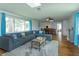 Spacious living room with a large sectional, hardwood floors and view into the dining room at 476 Zelda Blvd, Daytona Beach, FL 32118