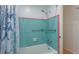 Tiled bathtub with shower showcasing blue tiled walls with a contrasting pink accent trim at 476 Zelda Blvd, Daytona Beach, FL 32118