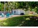 Backyard seating area next to shed with large tree and lawn at 5108 Sunrise Blvd, Orlando, FL 32803
