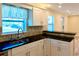 Close-up of updated kitchen showcasing dark countertops, stainless sink and backsplash at 5108 Sunrise Blvd, Orlando, FL 32803