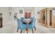 Cozy dining area with a glass-top table, blue chairs, and travertine flooring at 5170 Ne 64Th Ave, Silver Springs, FL 34488